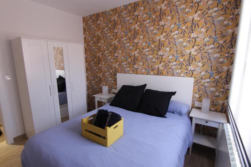 Un dormitorio con una cama con una caja amarilla. en Xixili en Bermeo