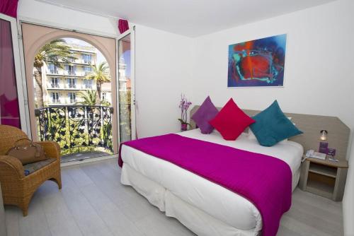 a bedroom with a large bed and a balcony at Cristal Hôtel & Spa in Cannes