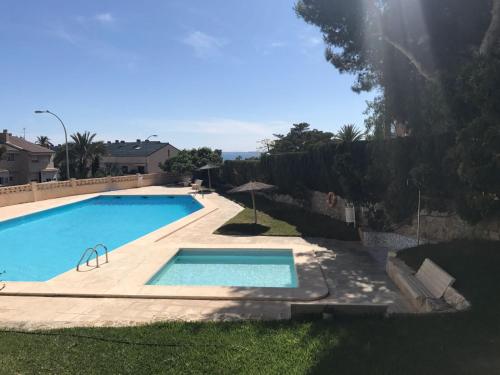 uma piscina num quintal ao lado de uma casa em Minimalist house by the Mediterranean sea. em Alicante