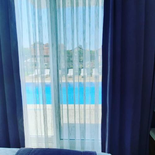 a window with blue curtains and a view of a building at Vespera hotel in Dalyan