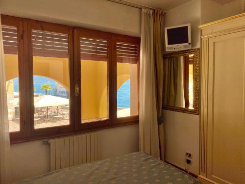 a bedroom with windows with a view of the ocean at Camere Al Veliero in Gardone Riviera