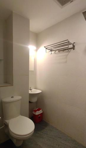 a bathroom with a toilet and a sink at Hotel Green Plaza in Trichūr