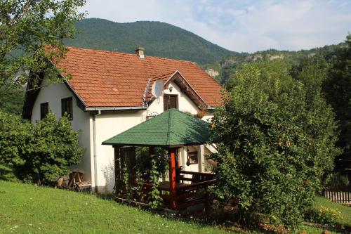 a small white house with a green roof at Apartment Sijakovic in Mokra Gora