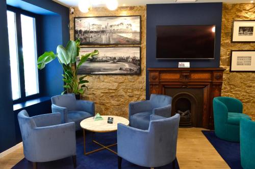 - une salle d'attente avec une table, des chaises et une télévision dans l'établissement Hotel Alda Galería Coruña, à La Corogne