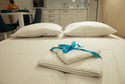 a pile of towels on a bed with two pillows at Turist Apartment in Niš