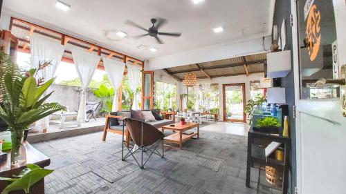 a living room with a ceiling fan and some plants at Beanbag Bintan Backpacker in Kangkakawal