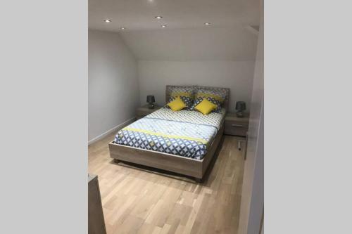 a bedroom with a bed with two yellow pillows at L alysé in Charleville-Mézières