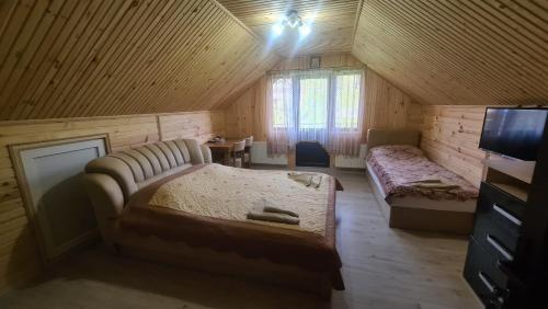 a bedroom with a bed and a couch in a room at Гостинний Двір Вишня in Bukovel