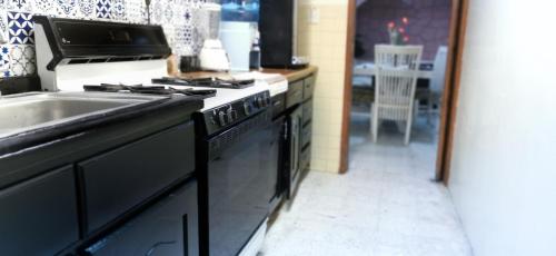 a kitchen with a stove top oven next to a sink at Casa Dahlia Querétaro in Querétaro