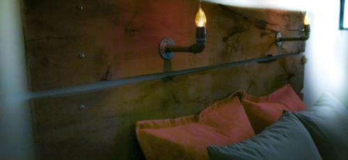 a candle is hanging on a wall with a bench at Casa Dahlia Querétaro in Querétaro
