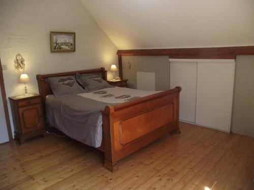1 dormitorio con 1 cama de madera y 2 mesitas de noche en chambres du grès rouge de Beauval, en Beauval