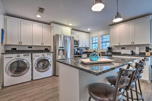 a kitchen with white cabinets and a counter with washing machines at Gulfport Bungalow by Jones ParkandBeach Access! in Gulfport