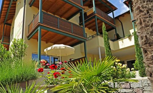 a building with balconies and flowers in a garden at Apparthotel Gartenresidence Nalserhof in Nalles