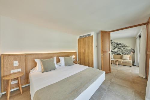a bedroom with a large bed and a living room at Sofia Alcudia Beach in Port d'Alcudia