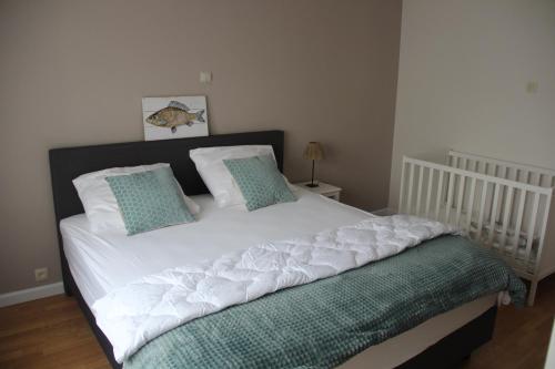 a white bed with two pillows on top of it at Huis Ter Duin in Koksijde