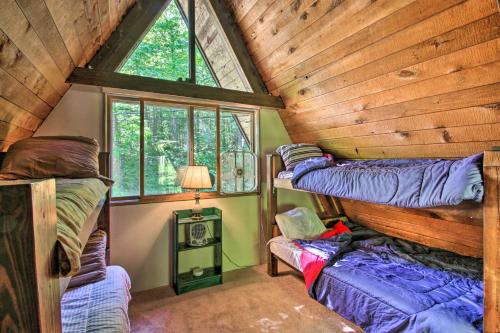 a room with two bunk beds and a window at Quiet A-Frame Cabin on Creek with Private Deck! in Rumney