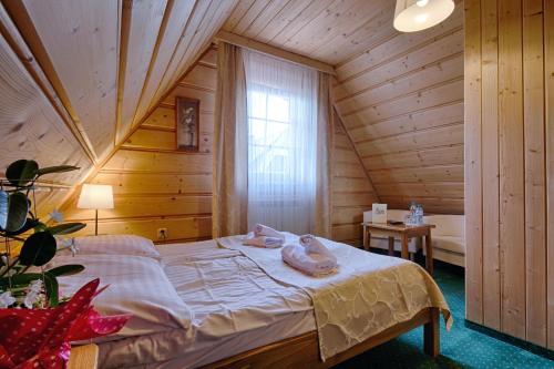 a bedroom with a bed in a wooden room at Góralski Gościniec & SPA in Poronin