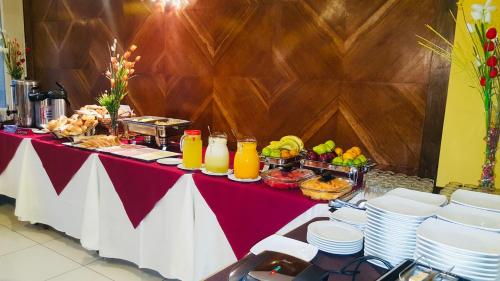 una mesa roja y blanca con comida y bebidas. en Hotel Continental Lima, en Lima