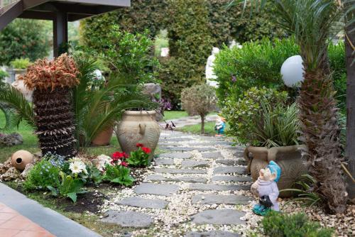 a garden with a stone path and flowers and plants at Ai confini dell Etna 1 in Nunziata