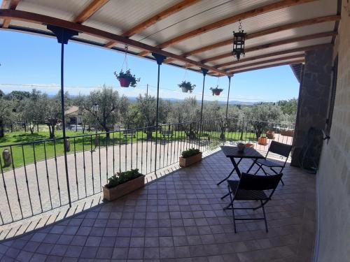 a patio with a table and chairs and a fence at B&B LE BACETTE in Caprarola