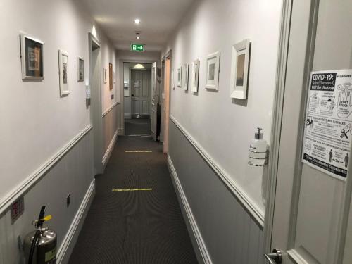 a hallway with a long hall with pictures on the walls at W12 Rooms in London