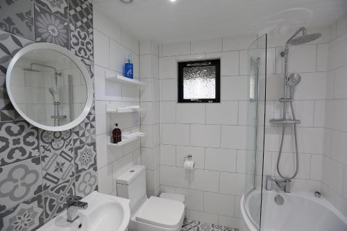 洛克亨黑德的住宿－Cosy Modern Nordic Lodge w/ Loch View & Log Burner，浴室配有盥洗池、卫生间和镜子。