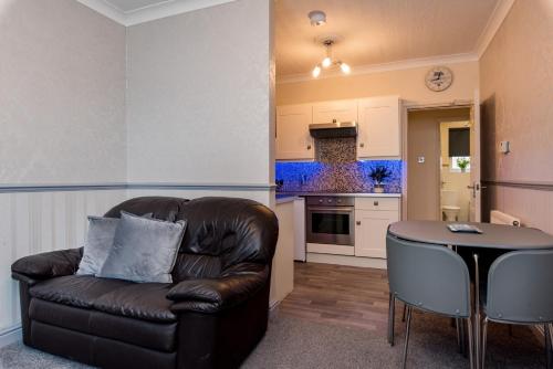 a living room with a leather couch and a table at Cattle Market View Apartment in Boston