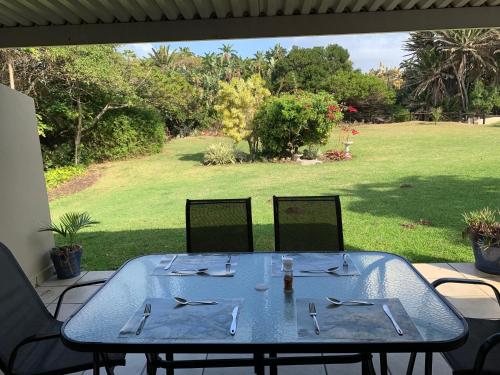 a blue table with chairs and a view of a yard at Sole's Leap in Scottburgh
