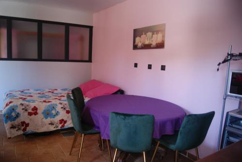 uma sala de jantar com uma mesa roxa e cadeiras em Gite de Rose Blanche em Belle-et-Houllefort