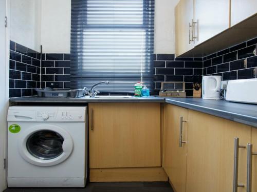 a kitchen with a washing machine and a sink at Dean House in Leeds