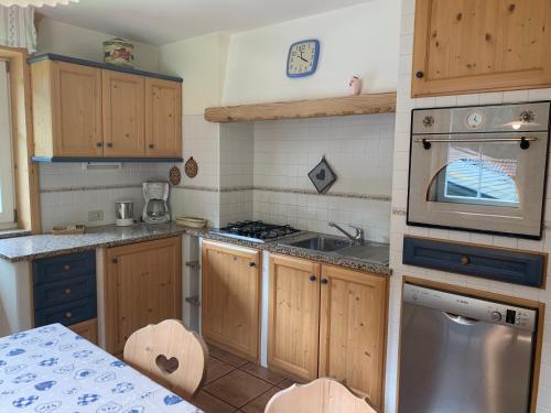 a kitchen with wooden cabinets and a stove top oven at Appartamenti Chalet Orchidea in Canazei