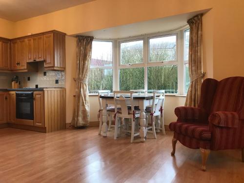 cocina con mesa y sillas y ventana grande en Dillon's Cottage, en Monneill