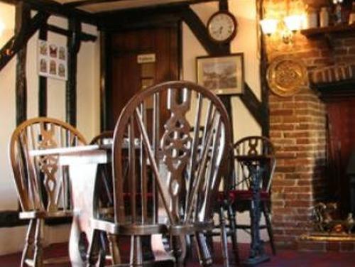 a dining room with a wooden table and chairs at The Dog Inn in Halstead