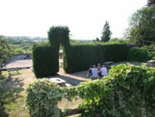 two people sitting on a bench in a hedge at The Dog Inn in Halstead
