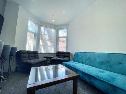 a living room with a blue couch and a coffee table at Mayfair Suite Sasco Apartments in Blackpool