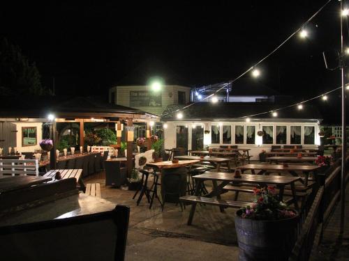 a restaurant with wooden tables and lights at night at Canal Cottages in Uxbridge