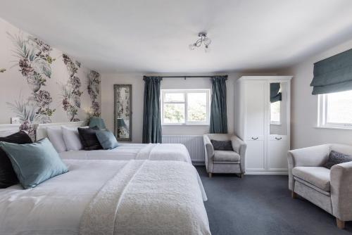 a bedroom with two beds and two chairs at The Mount Pleasant Hotel in Sidmouth