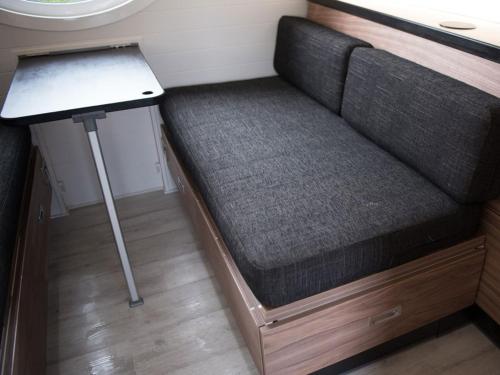 a couch in a room with a laptop on a table at Door to the Shore - Seafront Cottages in Sandhaven