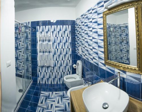a bathroom with blue and white tiled walls and a sink at Blu Marina in Vietri