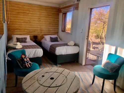 a room with two beds and a table and chairs at Atacama Loft & Glamp in San Pedro de Atacama