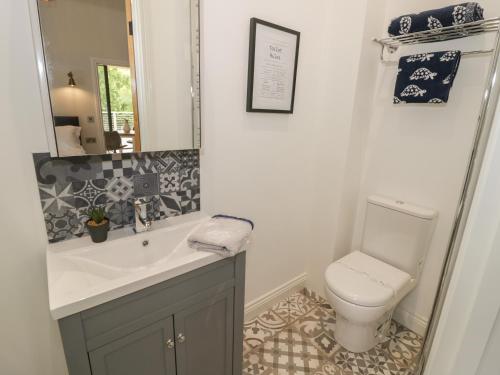 a bathroom with a sink and a toilet at The Barn in Redditch