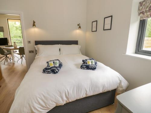 a bedroom with a bed with two pillows on it at The Barn in Redditch