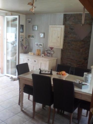 a kitchen with a wooden table and chairs at Le Valhento in Bouillon