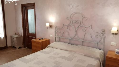 a bedroom with a bed with a metal headboard at Villa Mandrioli in Cecina