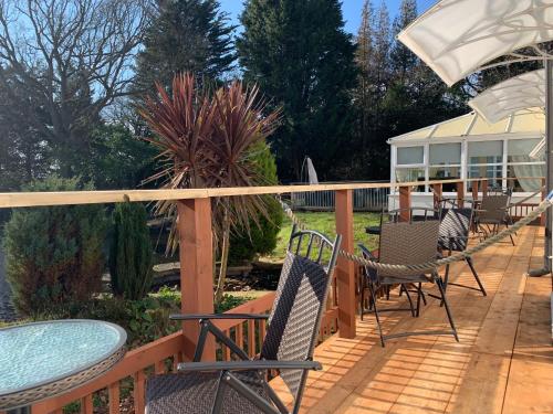 a deck with chairs and tables and a building at The Eiders in Aylmerton