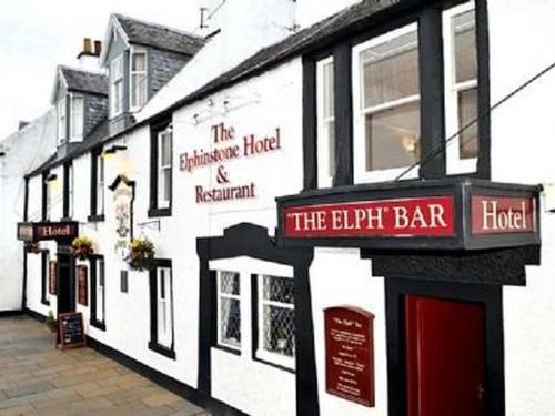 a white building with signs on the side of it at Elphinstone Hotel in Biggar