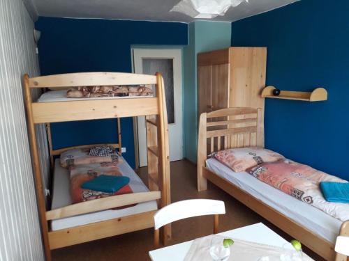 2 łóżka piętrowe w pokoju ze stołem w obiekcie Apartmán Pod Šeříkem w Czeskim Krumlovie