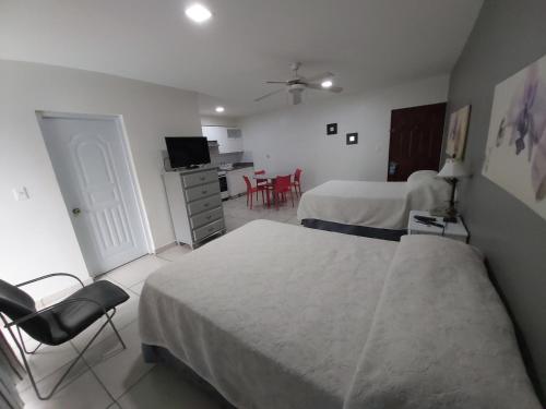 a hotel room with two beds and a table and chairs at Apart Hotel Turey in Santo Domingo