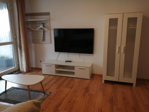 una sala de estar con TV de pantalla plana en un armario blanco en Hotel Princess, en Rodenbach