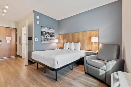 a hotel room with a bed and a chair at Extended Stay America Premier Suites - Melbourne - Palm Bay in West Melbourne